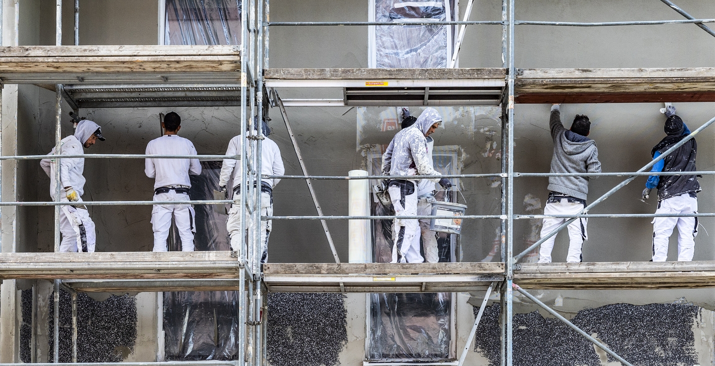 painter and plasterer workers on a scaffold to renovate a wall in Sunol, CA