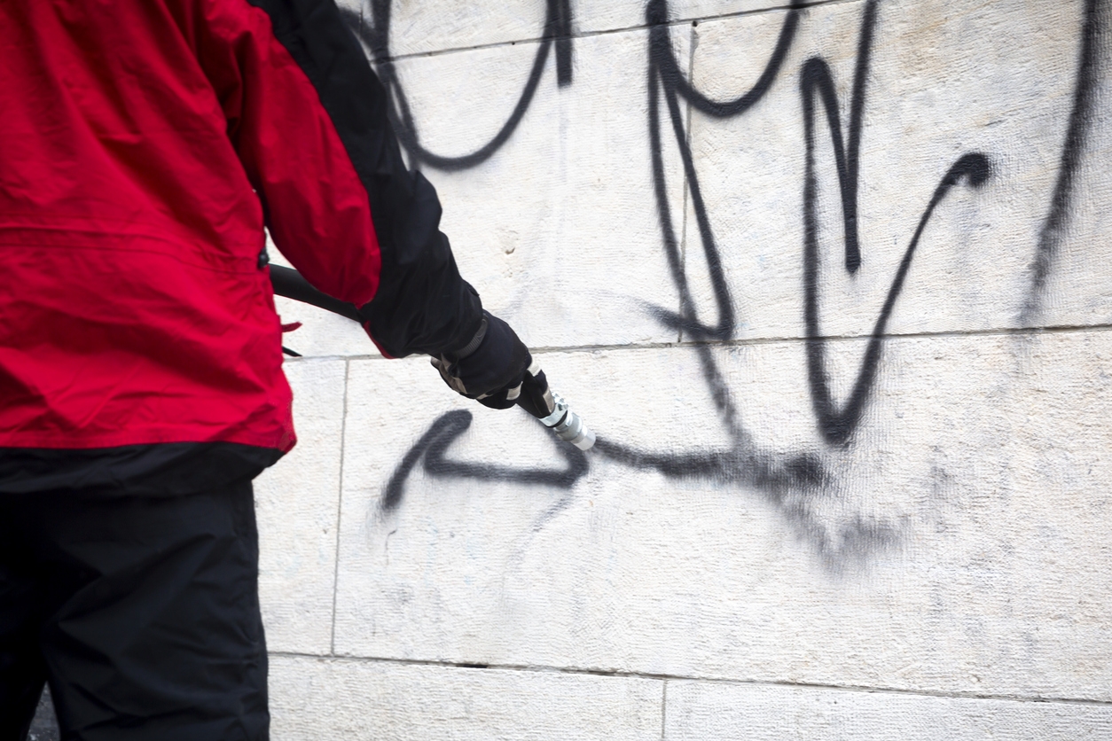 Worker cleaning graffiti off a Sunol, CA area business