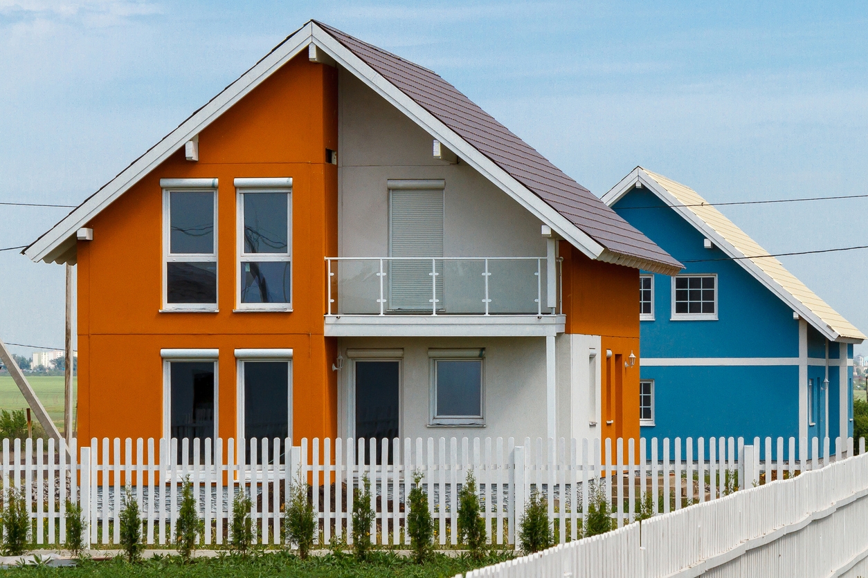 Orange and blue new houses behind a white fence in the Mountain View area