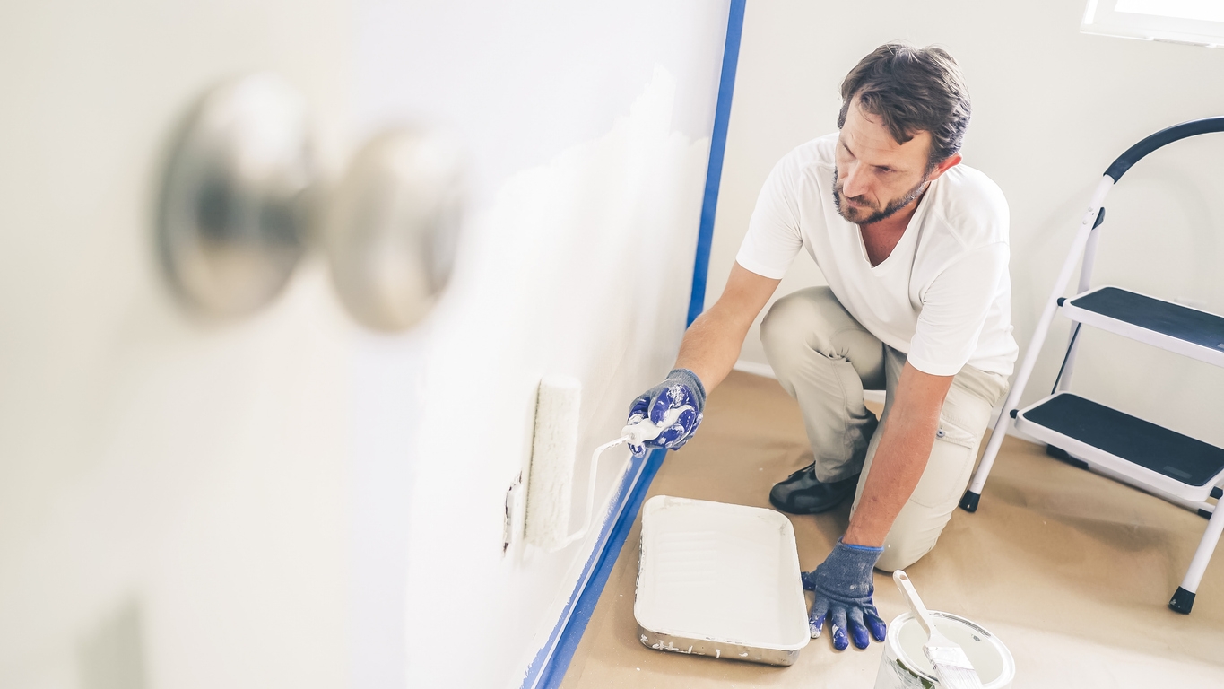 Painting the wall in home, with paint roller and white color paint. Room renovations at Santa Cara house.
